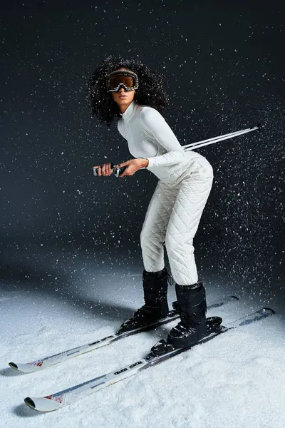 A stylish woman dressed in a ski suit stands confidently, ready to hit the slopes in a winter wonderland. — Stock Photo