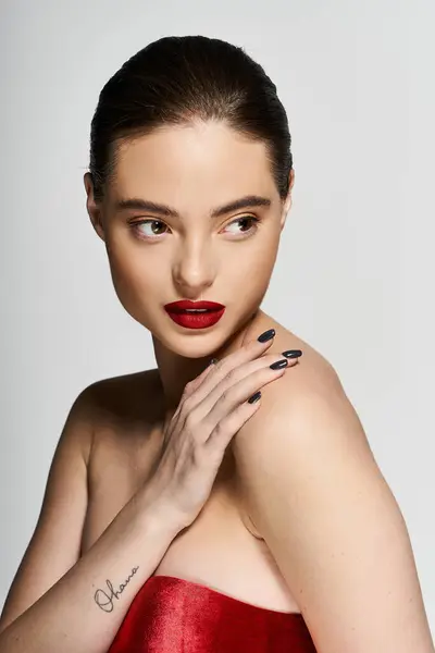 Una donna splendida posa con grazia con una mano sulla spalla, trasudando fiducia e fascino. — Foto stock