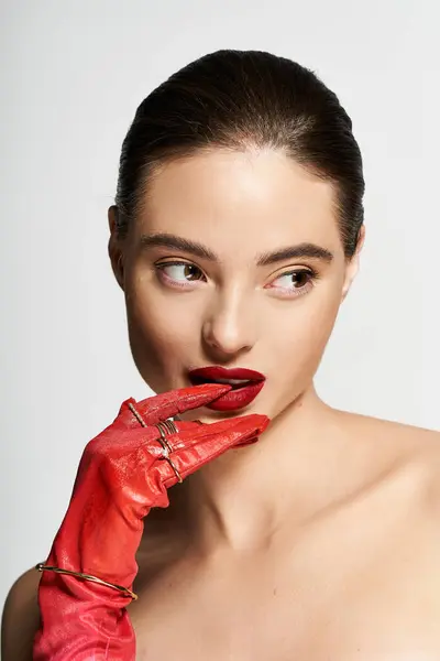A striking woman with captivating features displays poise while gently touching her lips. — Stock Photo