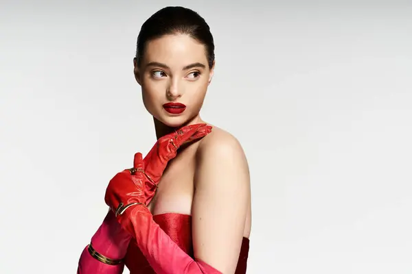 A stunning woman showcases her elegance with vibrant gloves while exuding confidence. — Stock Photo