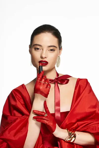 The elegant woman poses with red gloves, showcasing her bold lipstick choice and striking style. — Stock Photo
