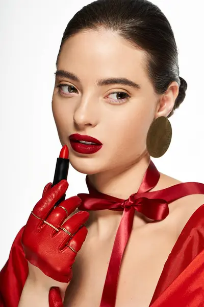 A stunning woman enhances her look with striking red lipstick and statement accessories. — Stock Photo
