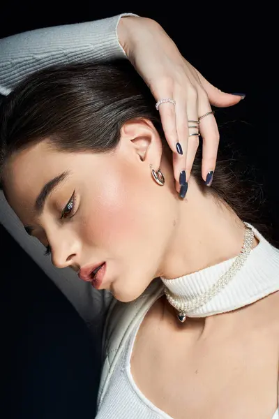 A graceful woman poses with jewelry, highlighting elegance and sophistication in warm light. — Stock Photo