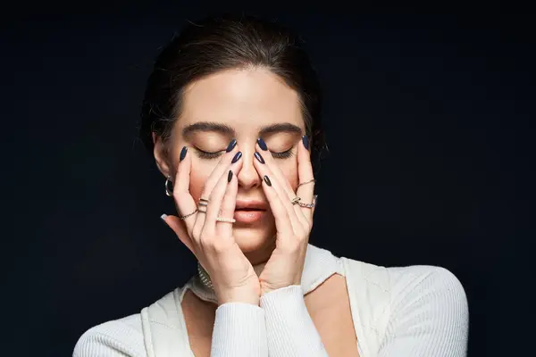 A beautiful woman enjoys a tranquil moment, her hands resting on her face, eyes gently closed. — Stock Photo