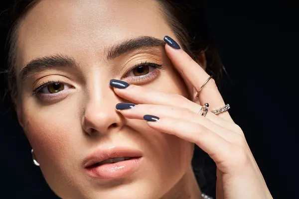 La mujer impresionante enfatiza sus características mientras que muestra joyas elegantes y manicura. — Stock Photo