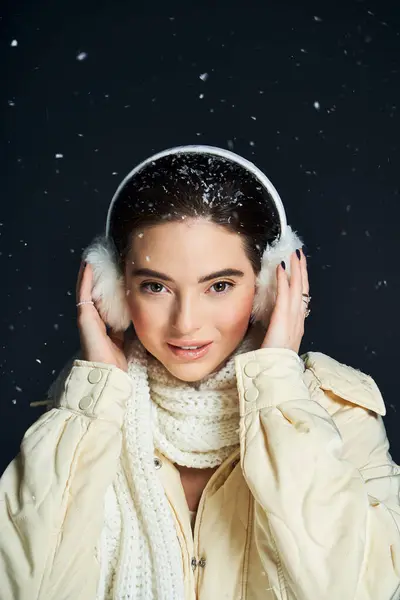 A woman embraces the winter season, smiling as soft snowflakes gently fall around her. — Foto stock