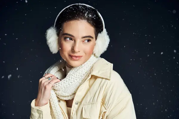 Una donna elegante sorride felicemente mentre i fiocchi di neve cadono delicatamente intorno a lei durante l'inverno.. — Foto stock