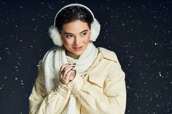 A lovely woman smiles while embracing the chilly winter weather, wrapped in a warm scarf. — Stock Photo