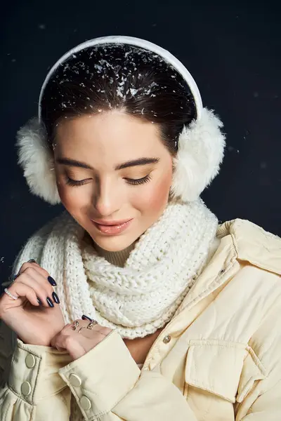 Una bella donna, ornata con abiti invernali accoglienti, gode dolcemente della nevicata intorno a lei.. — Foto stock