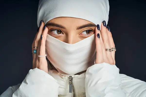 A woman gracefully poses with her hands near her face, highlighting her exquisite style. — Stock Photo