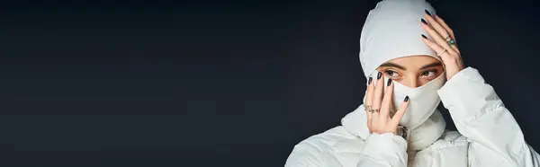 Модная женщина в белом наряде вдумчиво смотрит, регулируя капот.. — стоковое фото