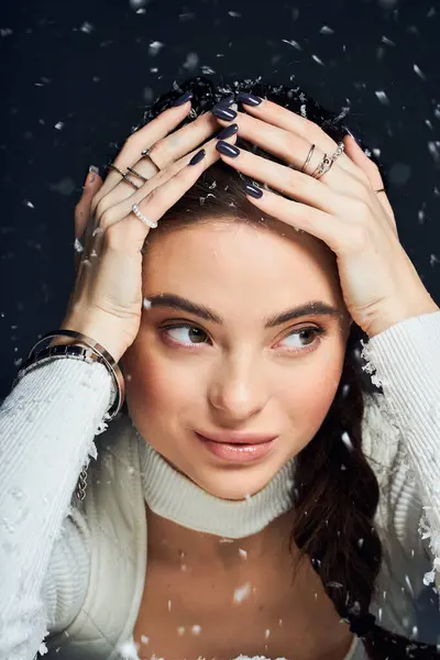 Una bella donna con i capelli scuri riflette mentre la neve leggera cade dolcemente intorno a lei. — Foto stock