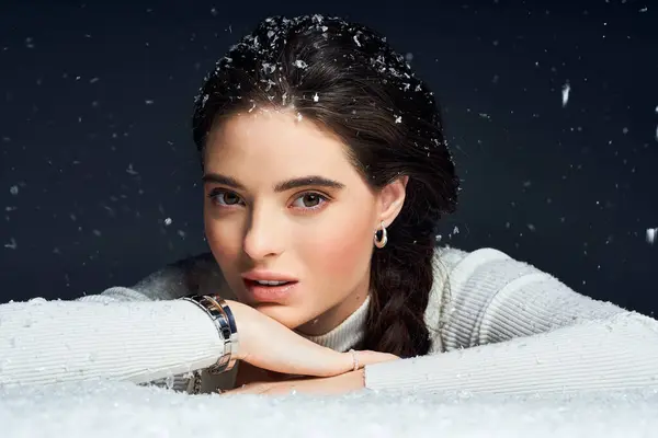 Una mujer encantadora disfruta de la belleza del invierno mientras abraza delicados copos de nieve a su alrededor. - foto de stock