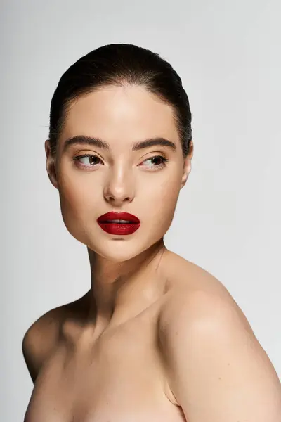 A captivating woman displays her beauty with bold red lips and a minimalist backdrop. — Stock Photo