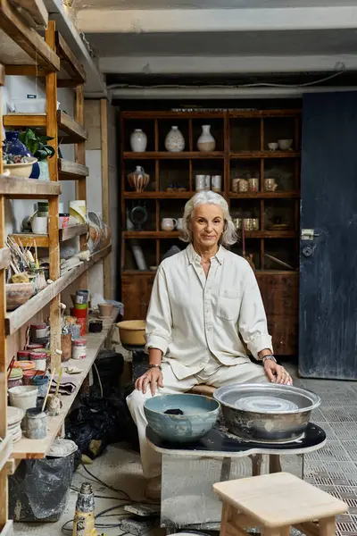 A skilled artisan is shaping ceramics in her warm, inviting studio filled with crafts. — Stock Photo