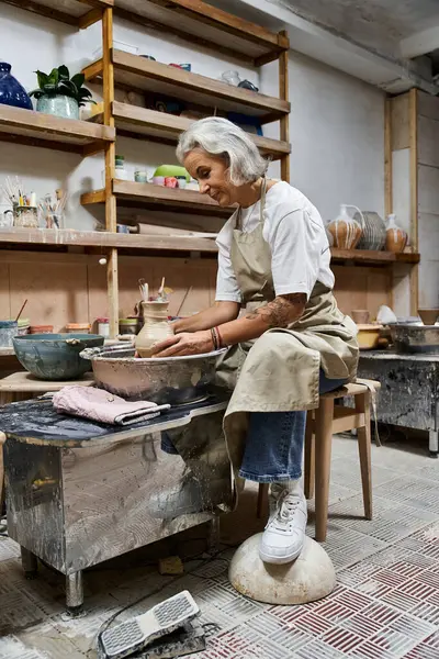 A talented artisan focuses intently on molding clay, enveloped in a warm and inspiring workspace. — Stock Photo