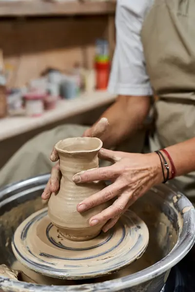 A talented woman expertly molds wet clay on a potters wheel, showcasing her craftsmanship. — Stock Photo
