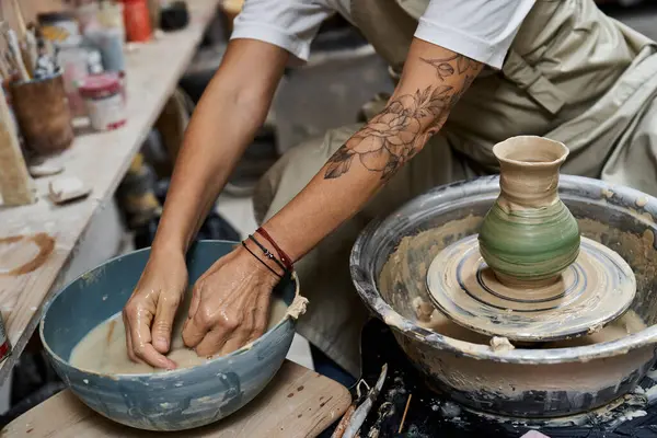 Hands of an experienced woman skillfully mold clay on a pottery wheel in a bright studio. — Stockfoto