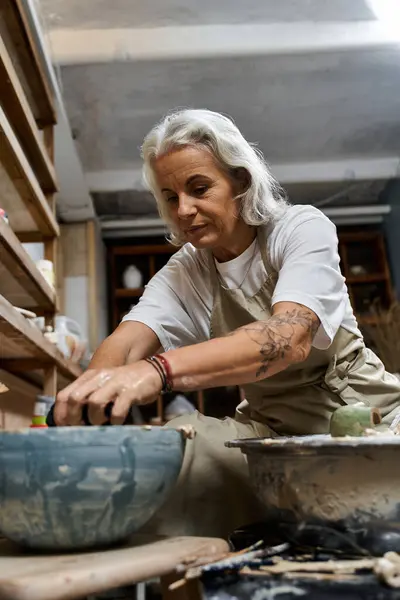 Una donna esperta lavora diligentemente con l'argilla, creando bellissime ceramiche nel suo laboratorio — Foto stock