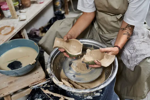 A skilled mature woman works with clay, forming beautiful pieces at a pottery wheel in her studio. — Stock Photo