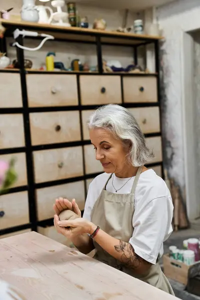 Ein talentierter Handwerker fertigt ein schönes Stück Keramik in einem warmen und einladenden Arbeitsbereich. — Stockfoto