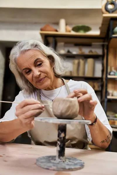 A talented artisan carefully shapes clay on a wheel, showcasing her creativity and passion. — Stock Photo