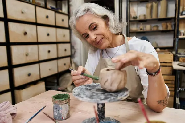 Una donna di talento si diverte a creare un bel pezzo di argilla nel suo affascinante spazio di lavoro in ceramica. — Foto stock