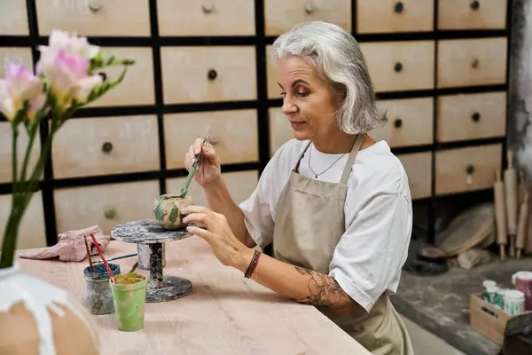 A skilled, mature woman passionately crafts pottery to express her creativity. — Stock Photo