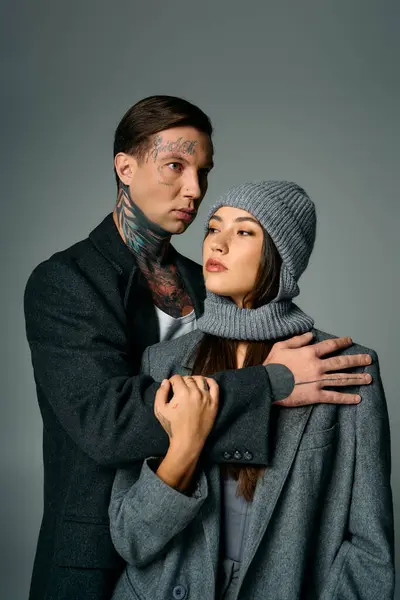 A young couple stands closely together, exuding a modern and fashionable vibe in winter attire. — Stock Photo