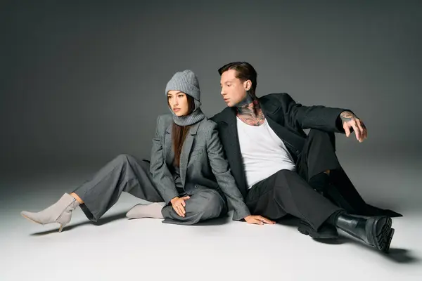 A young pair dressed in fashionable attire interacting in a chic studio environment — Stock Photo