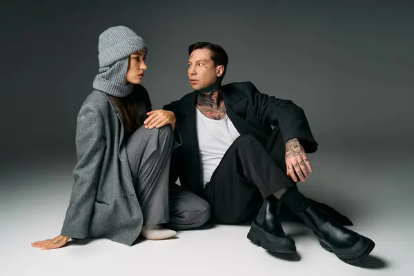 Um par elegante interage em roupas chiques, apresentando estilo contemporâneo e elegância. — Fotografia de Stock