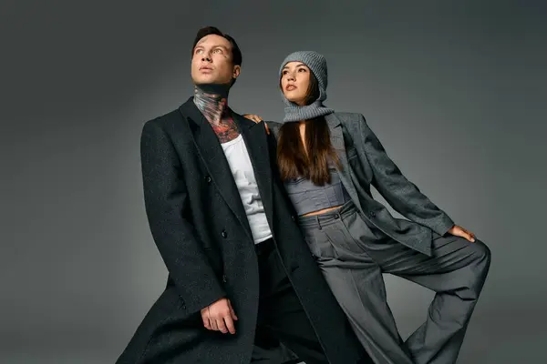 A young couple showcases modern outfits, exuding confidence and style in a creative studio setting. — Stock Photo