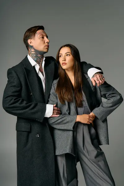 A stylish young man and woman showcase modern fashion with striking confidence and elegance. — Stock Photo
