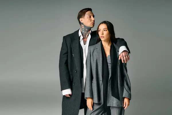 A young couple stands together, exuding elegance and confidence in chic attire. — Stock Photo
