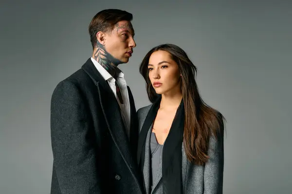 Una giovane coppia attraente sta vicino insieme, trasudando fascino e raffinatezza nella moda. — Foto stock