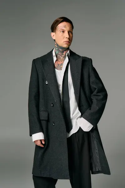 A confident young man displays modern fashion and unique tattoos. — Stock Photo