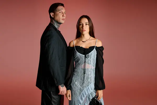 Un jeune couple se tient fièrement ensemble, affichant leur style unique et les regards frappants. — Photo de stock