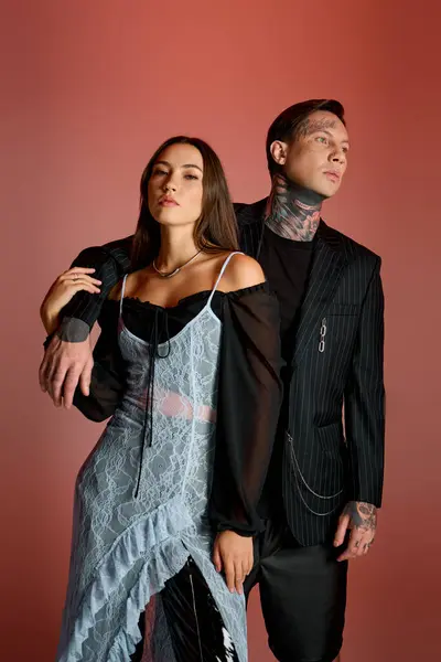 A striking couple poses together, blending contemporary style with eye catching tattoos. — Stock Photo
