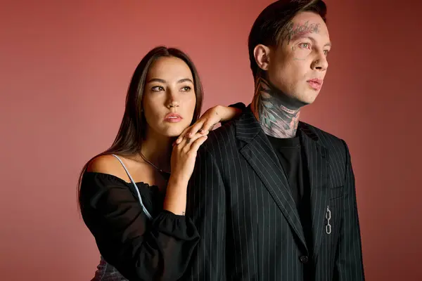 Una giovane donna si appoggia su un uomo in abiti eleganti, accentuando le loro scelte di moda uniche. — Foto stock