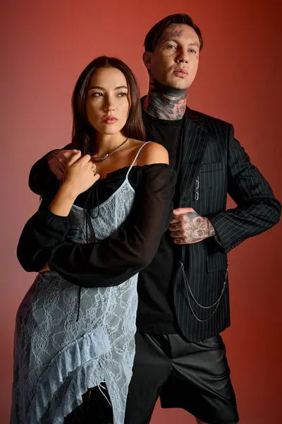 Couple exudes confidence and style in a trendy urban setting against a striking red backdrop. — Stock Photo