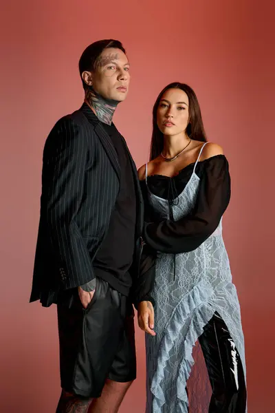 A stylish young couple showcases their unique fashion sense in a creative studio with vivid colors. — Stock Photo