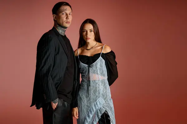 A stylish young couple poses together against a vibrant backdrop. — Stock Photo