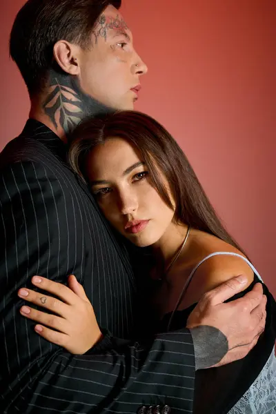 A young woman rests her head on the shoulder of a man in a formal suit, displaying intimacy. — Stock Photo