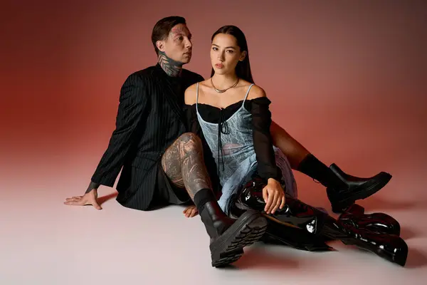 Um jovem casal impressionante exibe seu traje elegante enquanto sentado elegantemente juntos. — Fotografia de Stock