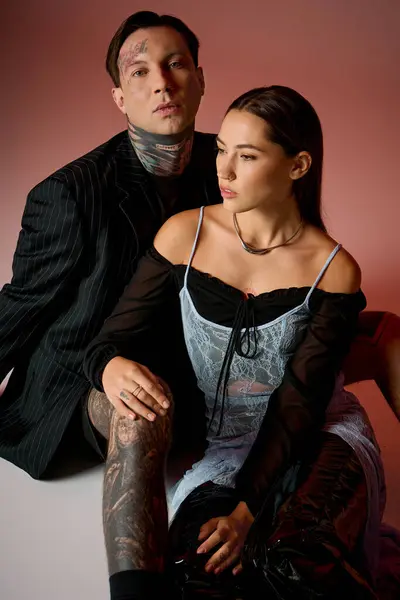 Una coppia alla moda posa strettamente insieme, mettendo in mostra i loro stili e tatuaggi unici. — Foto stock