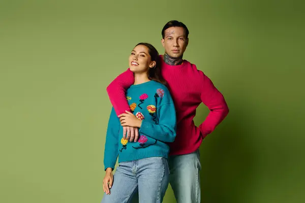 A young couple smiles closely in colorful sweaters, showcasing their bond. — Stock Photo