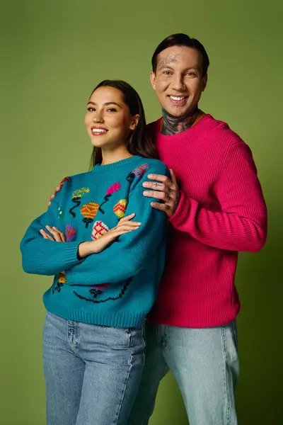 A young and attractive couple poses happily in stylish sweaters, smiling warmly at the camera. — Stock Photo