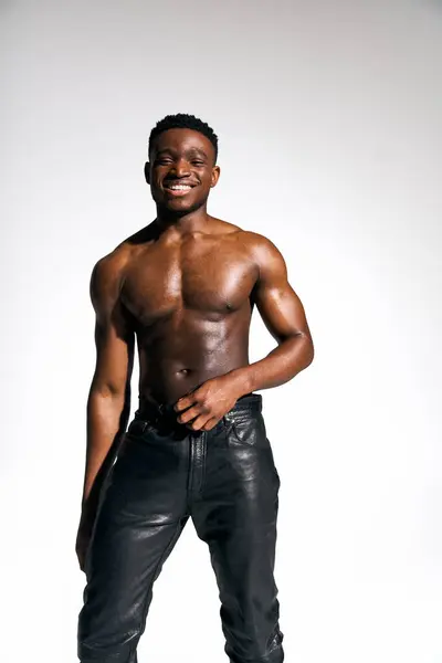 A young, handsome African American man stands confidently with a charming smile and a relaxed pose. — Stock Photo