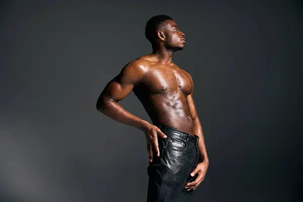 A young, handsome African American man stands tall, showcasing his sculpted torso and strong physique. — Stock Photo