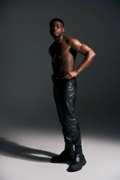 A striking young man exudes confidence while posing topless against a minimalist backdrop. — Stock Photo